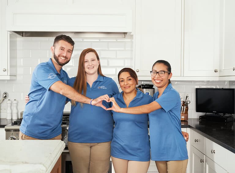 Maid Brigade team forming a heart with their hands
